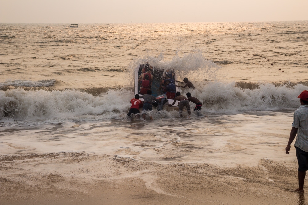 Intentado sobrepasar las fuertes olas de la orilla. Anjuna, Goa